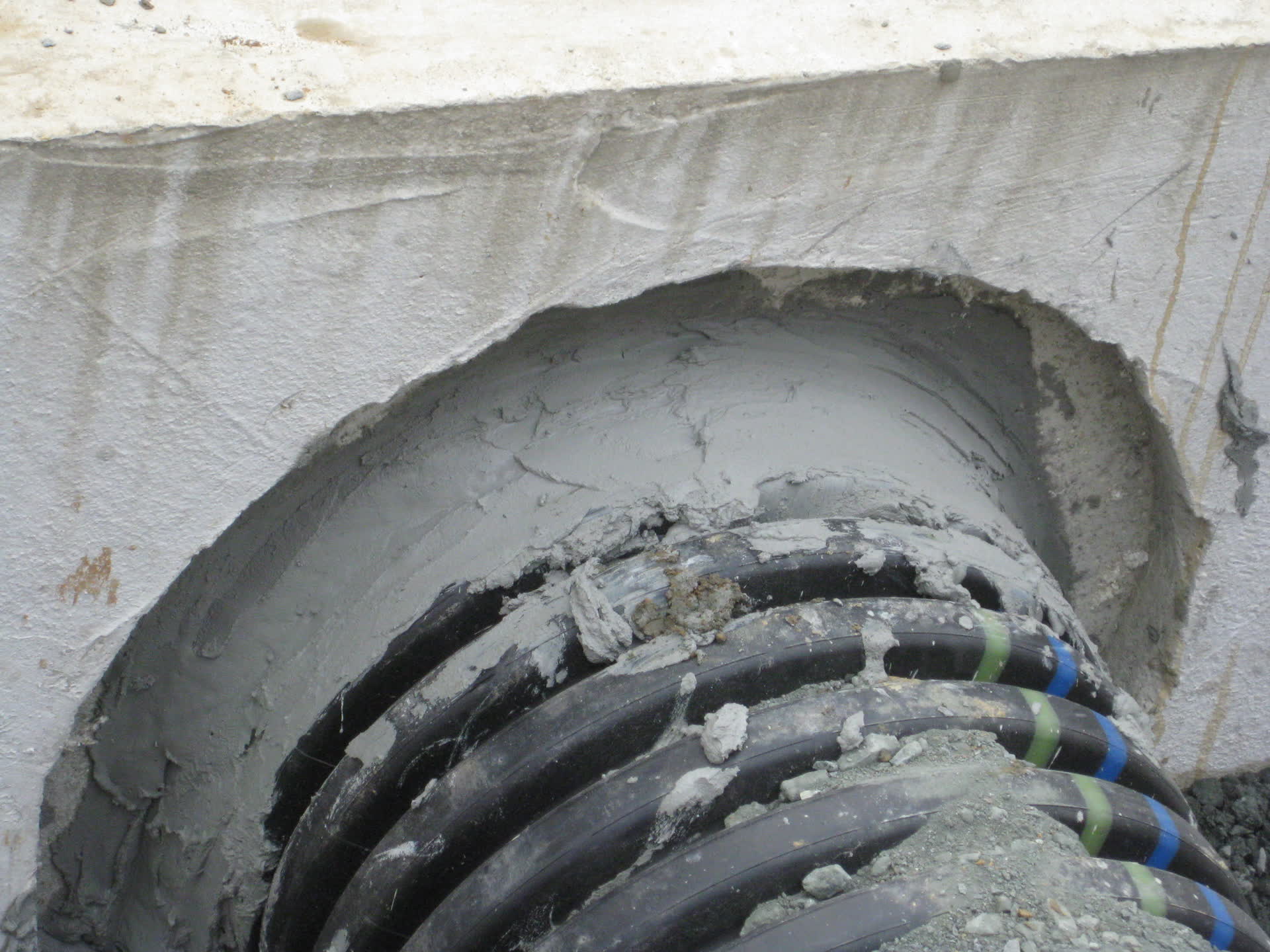 Pipe bedded and grouted into a headwall