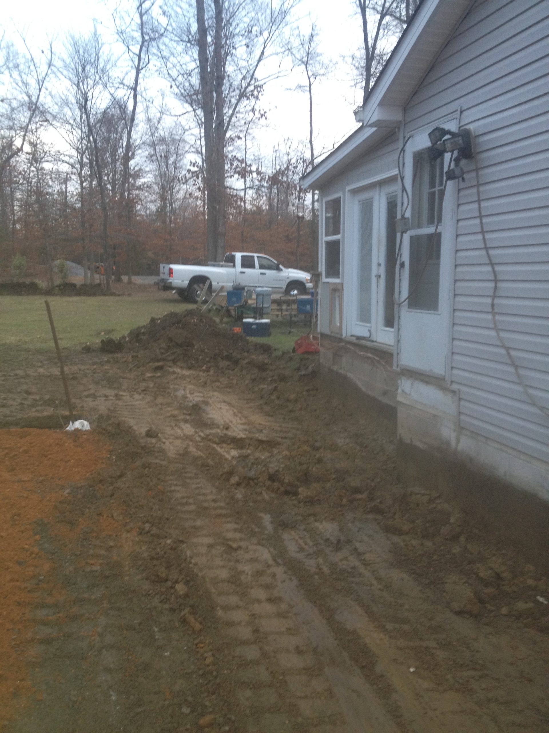 Freshly graded lot beside a house ready for seeding